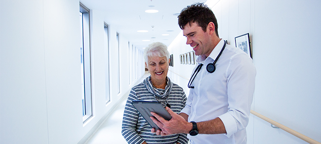 clinician showing older woman how to enroll in online course