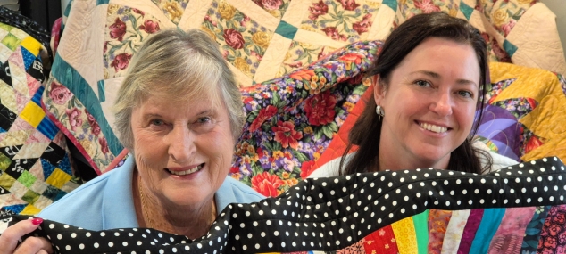 Mental Health Support Group Founder Barbara Swain (left) with Tuckeroo Occupational Therapist Angie D’Elboux surrounded by the 25 handmade quilts donated to the mental health unit. 