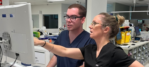 Male and female clinical staff looking at a mobile cart in a hospital environment