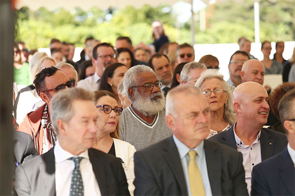 invited guests listen to speakers under a marquee at official opening of TVH